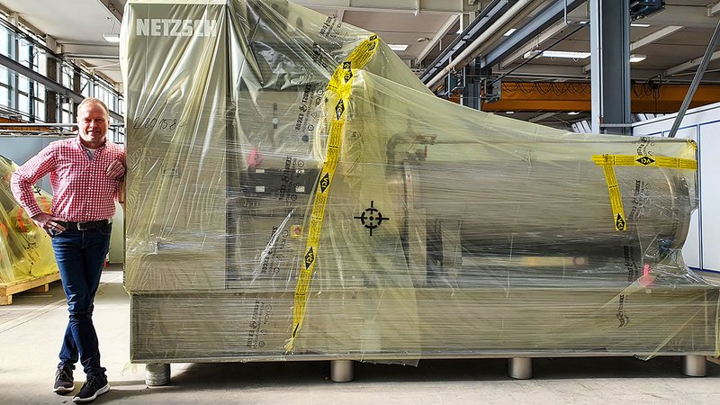 Una máquina envuelta en película ICB. A su lado, Hans-Jürgen Glettner, Director de Operaciones de Netzsch-Feinmahltechnik GmbH en Selb.